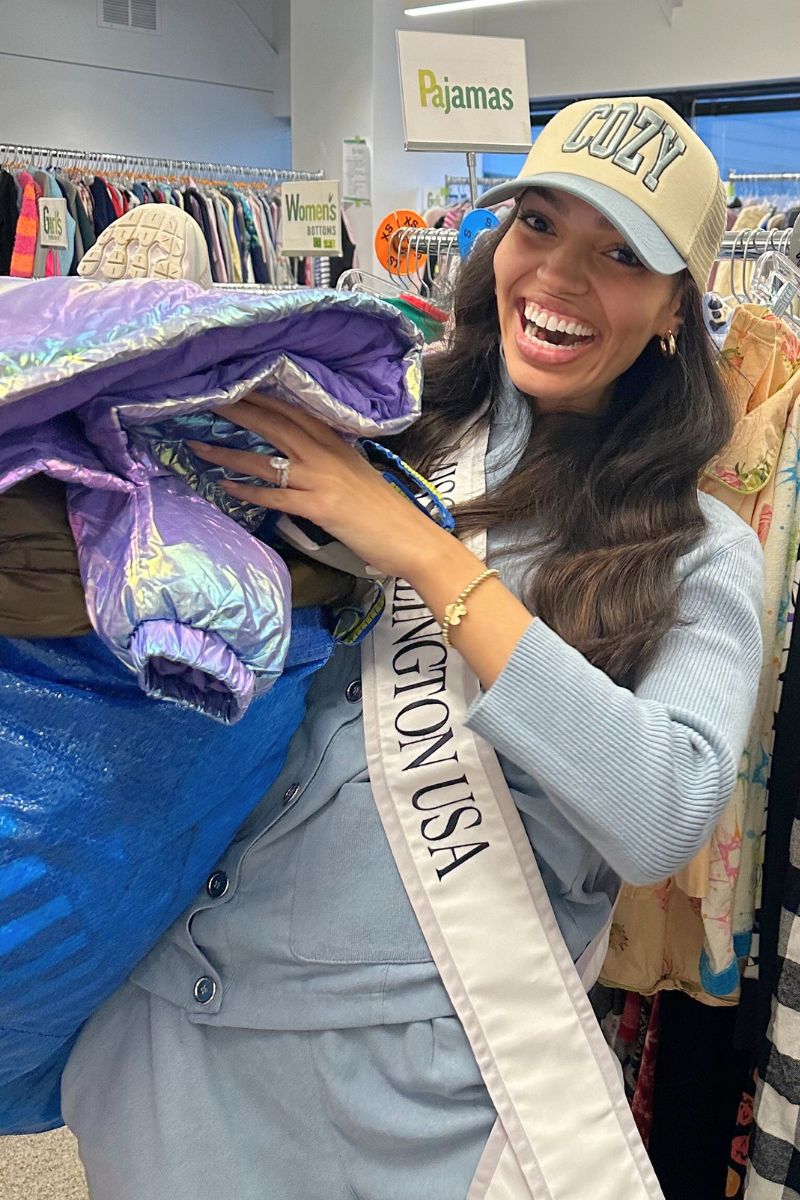 mujer sosteniendo ropa y sonriendo